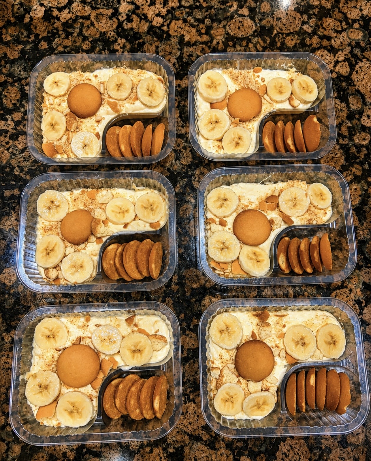 Close-up of banana pudding containers with a side of vanilla wafers